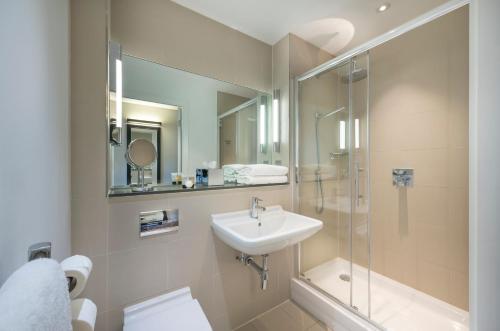 a bathroom with a sink and a shower and a toilet at The Resident Liverpool in Liverpool