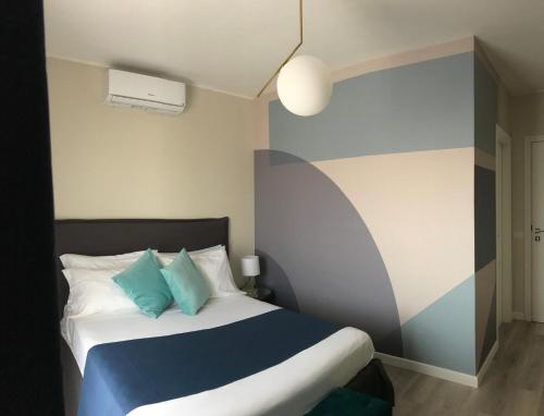 a bedroom with a bed with blue and white pillows at B&B Seataly by W Signature Experiences in Civitavecchia
