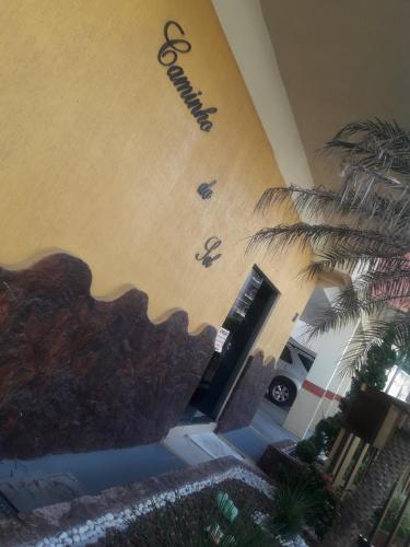 a building with a palm tree in front of it at Edificio caminho do sol in Arraial do Cabo