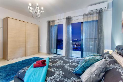 een woonkamer met een bank en een groot raam bij Modern 2BR Sliema Apartment in Sliema