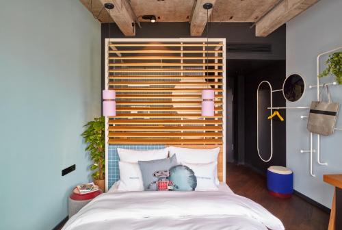 a bedroom with a large bed with a wooden headboard at 25hours Hotel The Circle in Cologne