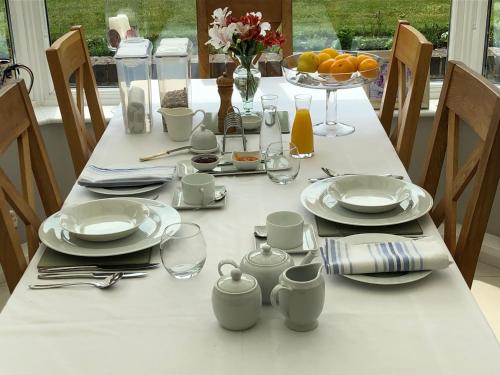 a white table with plates and glasses on it at Hysett House in Cocking