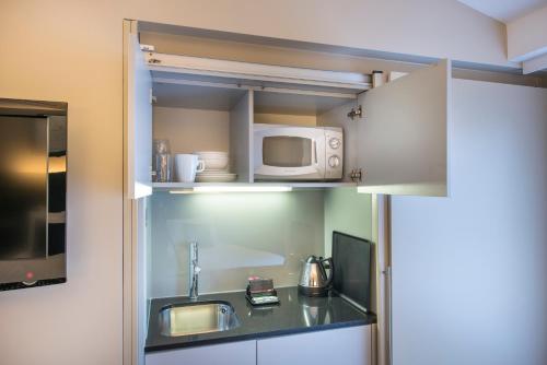 a small kitchen with a sink and a microwave at The Resident Liverpool in Liverpool