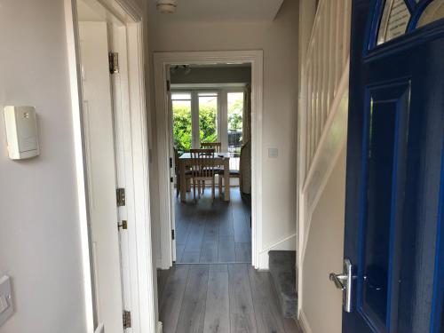 a hallway with a blue door and a dining room at Jubilee House in Oakham
