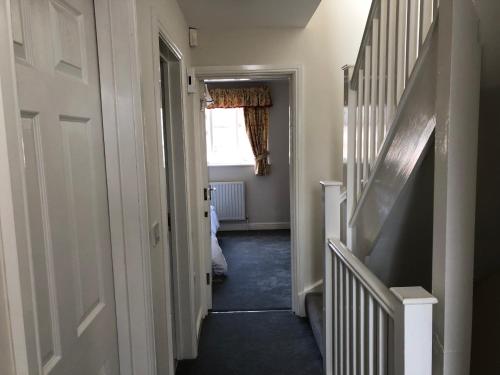 a hallway with a stairway leading to a room at Jubilee House in Oakham