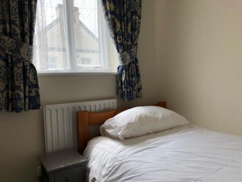 a bedroom with a bed with a pillow and a window at Jubilee House in Oakham