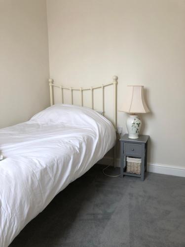 a bedroom with a bed and a table with a lamp at Jubilee House in Oakham