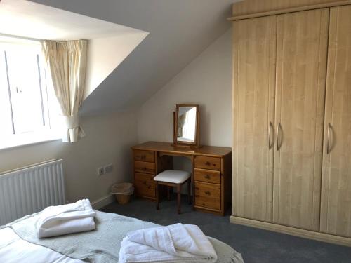 a bedroom with a bed and a dresser and a mirror at Jubilee House in Oakham