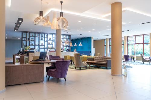 a lobby of a hotel with tables and chairs at Mercure Jelenia Góra in Jelenia Góra