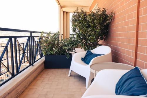 a balcony with two white chairs and plants at B&B Seataly by W Signature Experiences in Civitavecchia