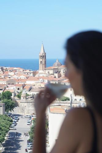 a woman taking a picture of a city at Hotel Catalunya in Alghero