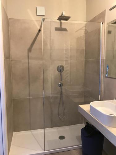 a shower with a glass door next to a sink at B&B Seataly by W Signature Experiences in Civitavecchia