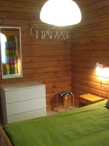 a bedroom with a bed and a table and a lamp at Loma-Rantala Cottages in Tahkovuori