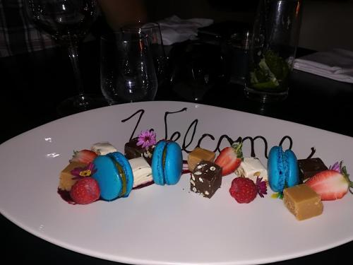 a white plate with chocolate desserts on it at A310 Lagoon Beach Apartment & Spa in Cape Town