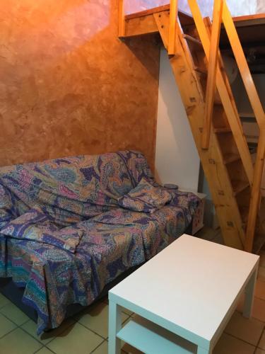 a couch and a table in a room with a stairs at Apartament Cala Magda Sant Llorenç de Montgai in Sant Llorenç de Montgai