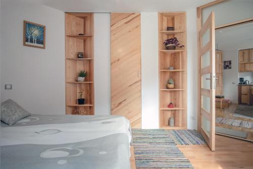 a bedroom with a bed and wooden shelves at Alt Apartament in Sibiu