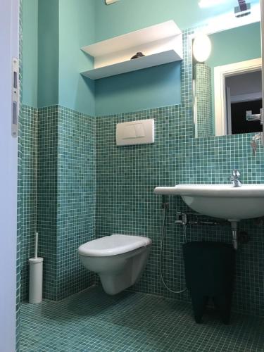 a green tiled bathroom with a toilet and a sink at B&B Seataly by W Signature Experiences in Civitavecchia