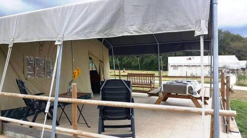 a tent with a table and chairs under it at Camping Parc de la Brenne in Lignac