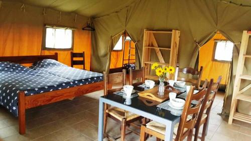 a room with a bed and a table in a tent at Camping Parc de la Brenne in Lignac