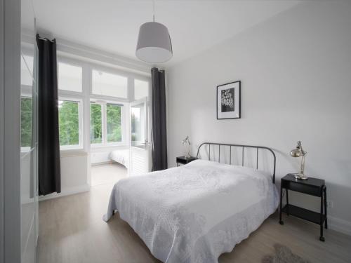 a white bedroom with a bed and a window at City Apartments Siegburg in Siegburg