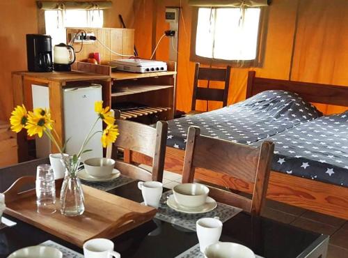 a dining room with a table and a bed at Camping Parc de la Brenne in Lignac