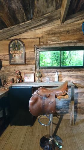 un siège en cuir devant un bar dans une cabine dans l'établissement La Cabane Aux Loups, à Crépy-en-Valois