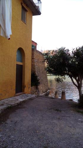 a building with a door next to a body of water at Apartament Cala Magda Sant Llorenç de Montgai in Sant Llorenç de Montgai