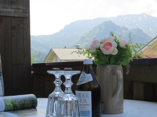 a table with two wine bottles and a vase with flowers at Pension Marianne - Chiemgau Karte in Inzell