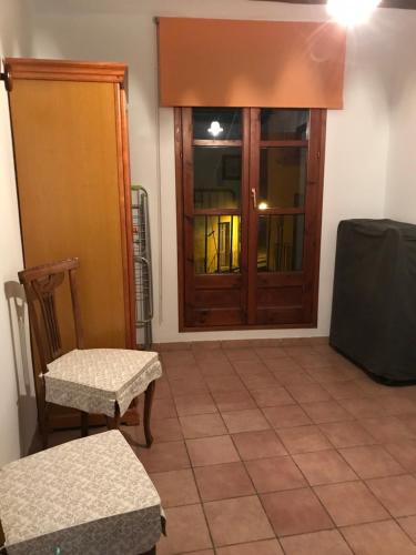a room with a door and two chairs and a window at Apartament Cala Magda Sant Llorenç de Montgai in Sant Llorenç de Montgai