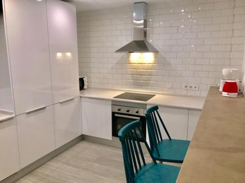 a kitchen with a stove and a chair in it at Lujoso duplex en la playa con vistas al mar in Torremolinos