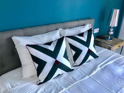 a bed with four pillows on it with a blue wall at Lujoso duplex en la playa con vistas al mar in Torremolinos