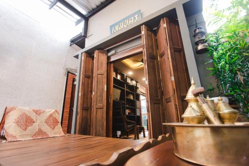 a restaurant with a wooden table in front of a store at Narra House Sukhumvit58 in Bangkok