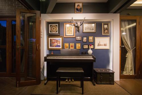 a blue wall with a piano in a room at Narra House Sukhumvit58 in Bangkok