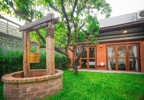 a brick fountain in the yard of a house at Narra House Sukhumvit58 in Bangkok