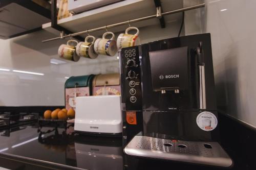 a kitchen with a black coffee maker on a counter at Narra House Sukhumvit58 in Bangkok