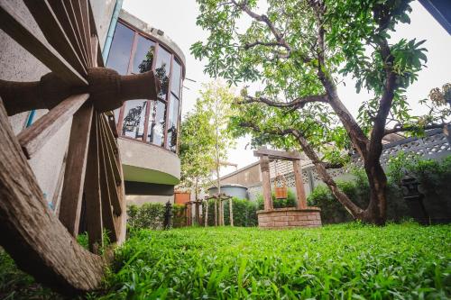 a building with a tree and a fence at Narra House Sukhumvit58 in Bangkok