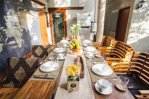 a wooden table with plates and bowls of fruit on it at Narra House Sukhumvit58 in Bangkok