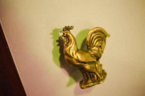 a gold rooster decoration on a wall at Narra House Sukhumvit58 in Bangkok