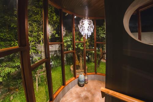 a room with a large window with a chandelier at Narra House Sukhumvit58 in Bangkok