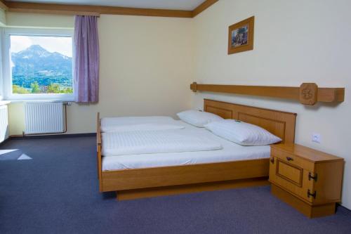 - une chambre avec un lit et une grande fenêtre dans l'établissement Haus Panorama, à Drobollach am Faakersee
