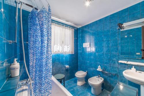 un bagno blu con vasca, servizi igienici e lavandino di Bed and Breakfast Miotto a Montegalda