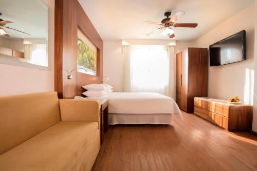 a hotel room with a bed and a couch at Krystal Grand Nuevo Vallarta in Nuevo Vallarta 