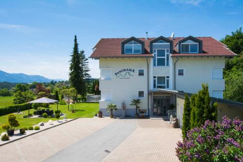 a large white building with a red roof at Haus Panorama in Drobollach am Faakersee