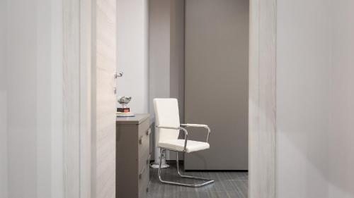 einen weißen Stuhl in einem Zimmer mit einem Schreibtisch in der Unterkunft Rental in Rome Archimede in Rom
