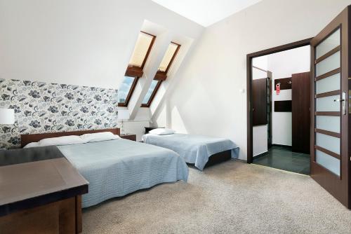 a bedroom with two beds and a mirror at Hotel Pod Kasztanami in Lublin