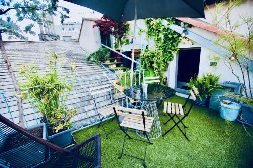 une terrasse avec une table, des chaises et un parasol dans l'établissement G.A.P. genova aquarium pentahouse, à Gênes