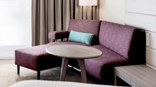 a living room with a purple couch and a table at Crowne Plaza Atlanta - Midtown by IHG in Atlanta