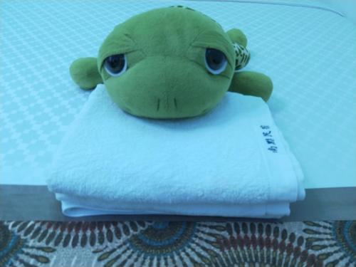 a stuffed frog sitting on top of a pile of towels at Nandian Homestay in Eluan