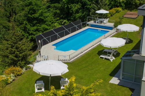 an overhead view of a swimming pool with umbrellas at Haus Panorama in Drobollach am Faakersee