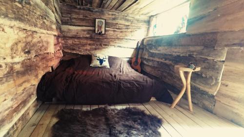 a small room with a bed in a brick wall at La Cabane Aux Loups in Crépy-en-Valois